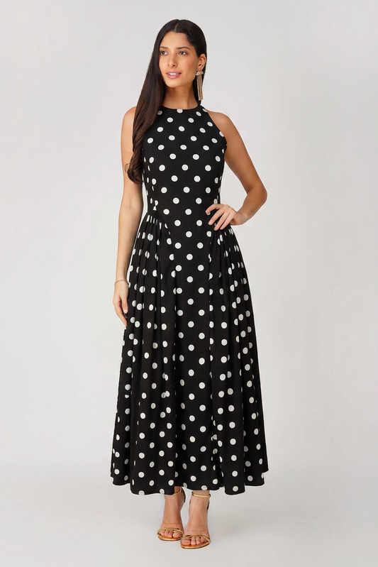 Woman wearing a black dress with white polka dots on a white background