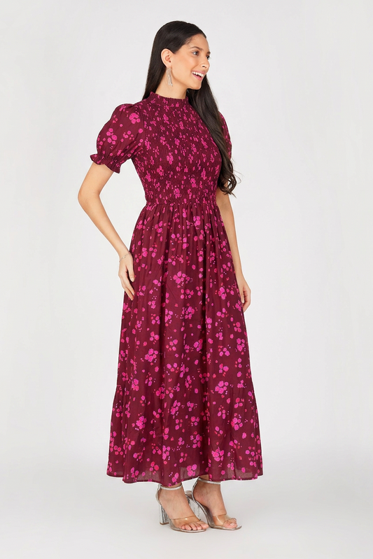 Woman wearing a magenta floral dress on a white background