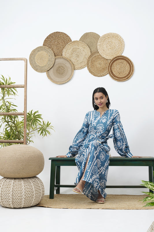 Tapered through the bodice & waist falling into an A-line skirt.  Concealed side zip fastening  Blouson sleeves with self covered buttons on the cuff.  Tie waist belt with tassel detailing.  Round neckline with zari detailing.  Featuring a slit at the centre front BEACH RESORT WEAR VACATIONS SUMMER DRESS